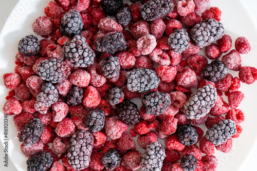 Raspberries and blackberries frozen  berries background. Selective focus