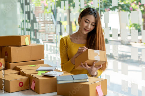 Start up successful small business owner, a freelance young Asian female merchant preparing a package box to deliver to customers, SME entrepreneurs, online business ideas, bloggers © PaeGAG