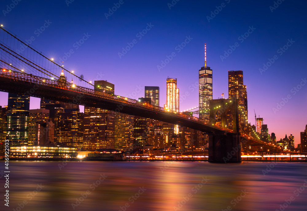 View of Brooklyn Bridge and Manhattan skyline WTC Freedom Tower from Dumbo by night, Brooklyn. Brooklyn Bridge is one of the oldest suspension bridges in the USA
