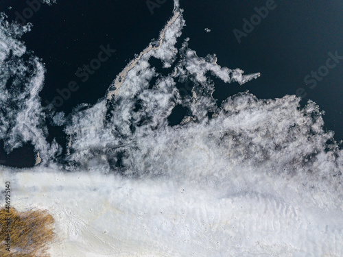 Ice melts on the river. Ice crack. Aerial drone view. Spring sunny morning.