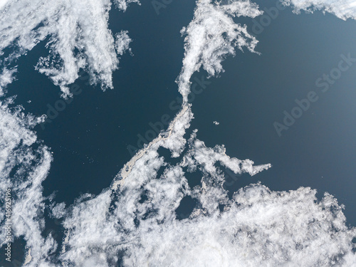 Ice melts on the river. Ice crack. Aerial drone view. Spring sunny morning.