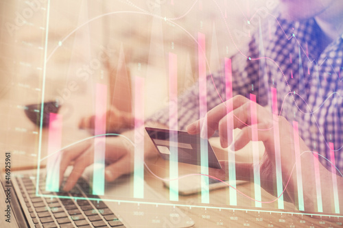 Double exposure of man hands holding a credit card and Forex graph drawing. Stock trading and digital fintech in Internet E-commerce concept. © peshkova