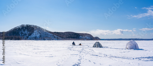 People catch fish on a frozen lake. Winter fishing © Vyacheslav