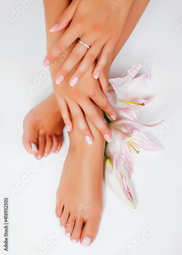 Fototapeta Naklejka Na Ścianę i Meble -  manicure pedicure with flower lily closeup isolated on white perfect shape hands spa salon