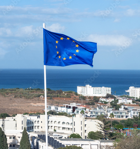 European Union flag on background of resort town and sea in Republic of Cyprus