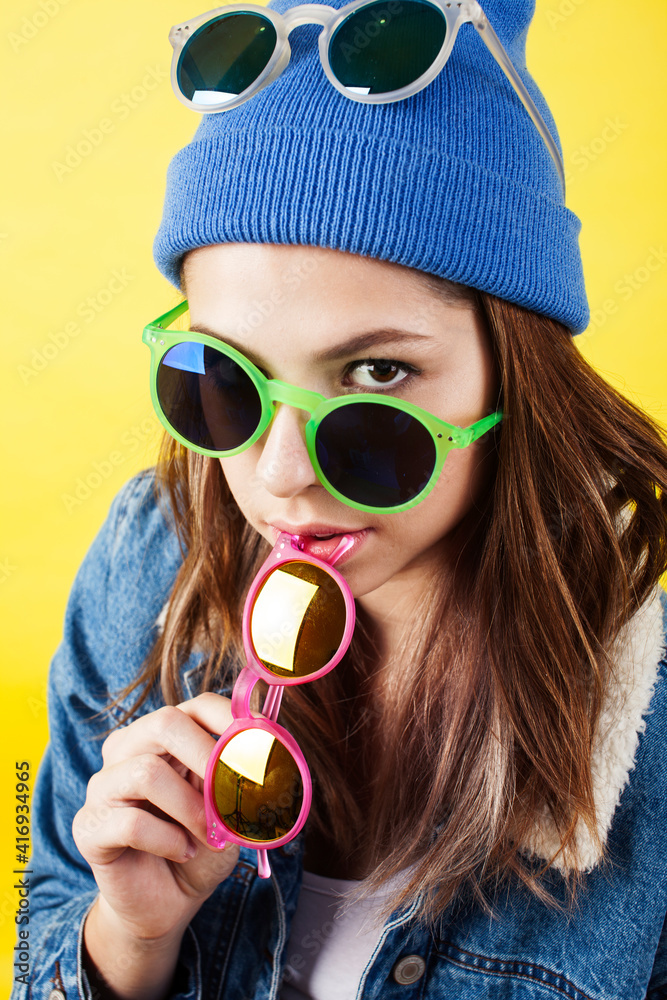 lifestyle people concept: pretty young school teenage girl having fun happy smiling on yellow background lifestyle people concept: pretty young school teenage girl having fun happy smiling on yellow background