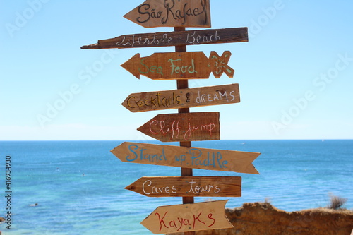 Wooden poster with arrows on the beach