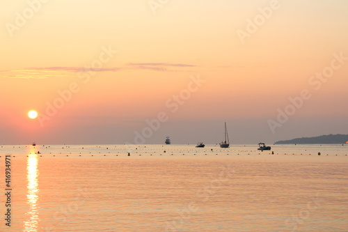 Sunrise on a beach with the reflection of the sun on the water 