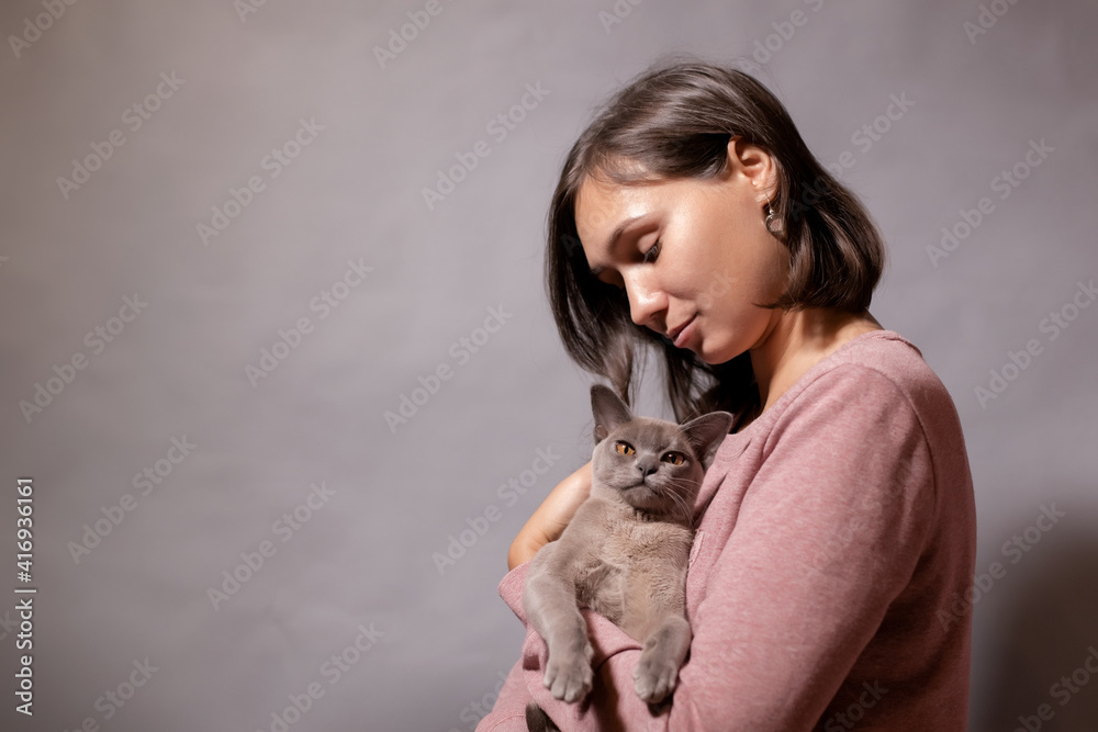 Young woman holding a gray cat in her arms Young woman holding a gray cat in her arms