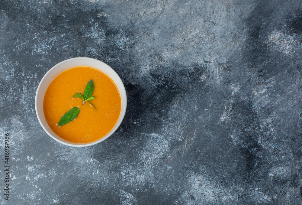 Top view of fresh homemade soup in white bowl over grey background Top view of fresh homemade soup in white bowl over grey background