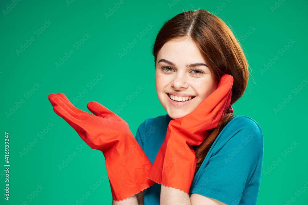 cheerful pretty woman in rubber gloves emotions green background cleaning