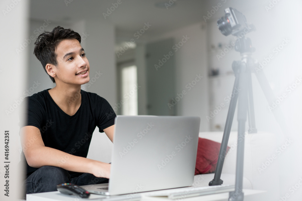 Young boy talking online using laptop and camera equipment Young boy talking online using laptop and camera equipment
