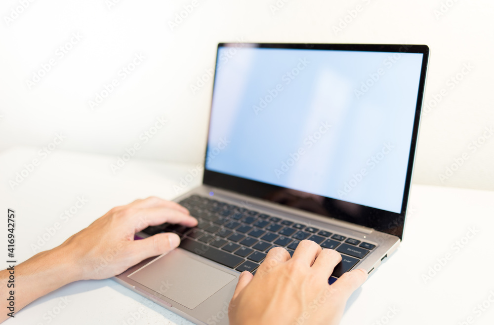 hands typing on laptop on a white table. hands typing on laptop on a white table.