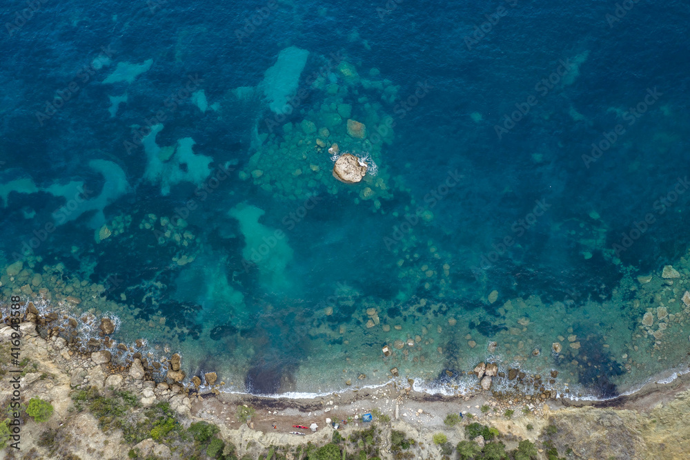 Aerial overhead drone shot of Adriatic coastline in Komiza town on Vis Island in Croatia summer