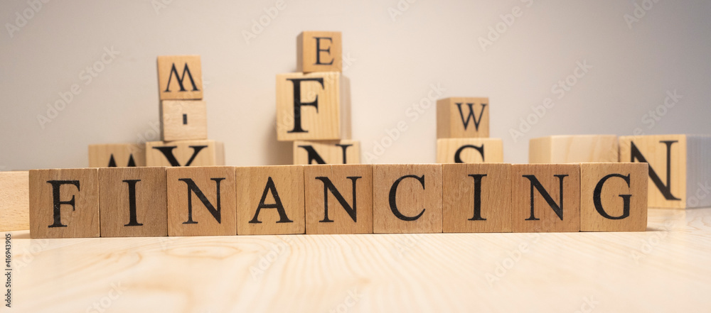 financing word from wooden cubes. Background from wooden letters. Close up.