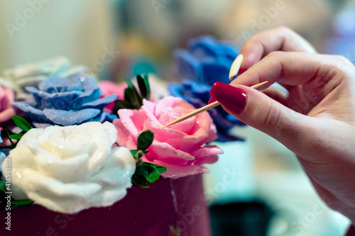 A woman makes flowers from soap. Artificial handmade flowers