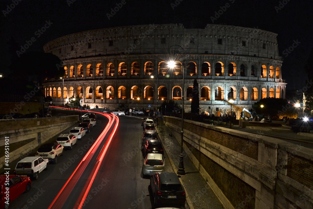 colosseum at night with red car lights 