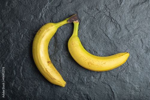 Top view of two fresh ripe bananas over black background