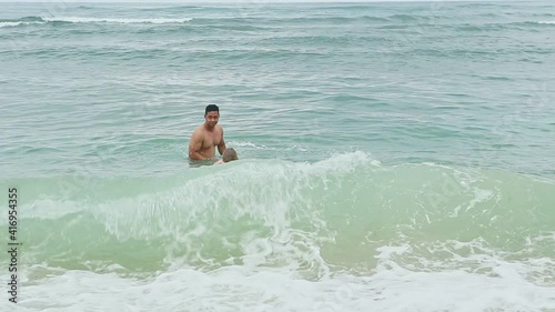 dark-skinned father and small blond girl in inflatable ring swim in deep blue ocean