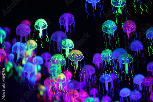 A smack of fluorescent jellyfish floating, marine life background