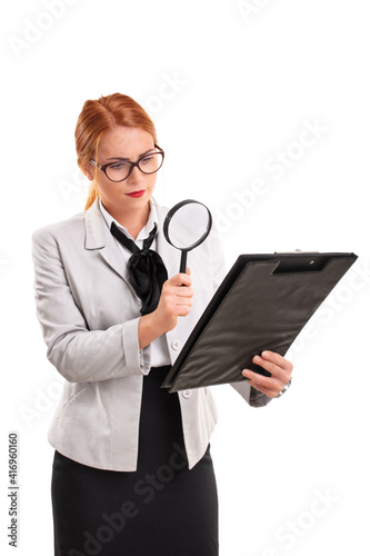 Businesswoman looking at document through magnifying glass
