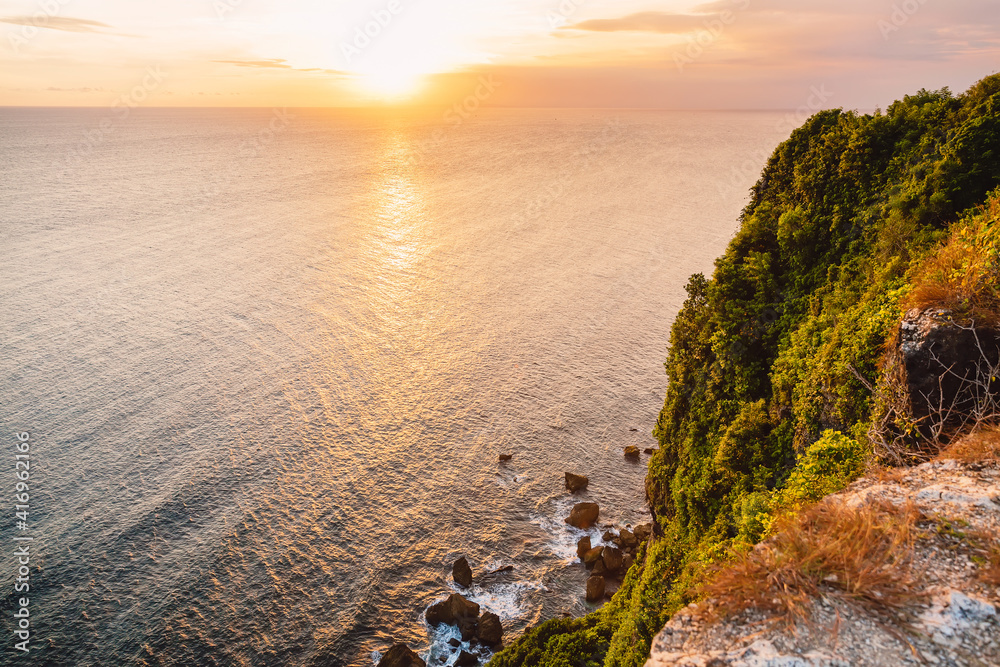 Ocean and cliff at sunset in Uluwatu, Bali