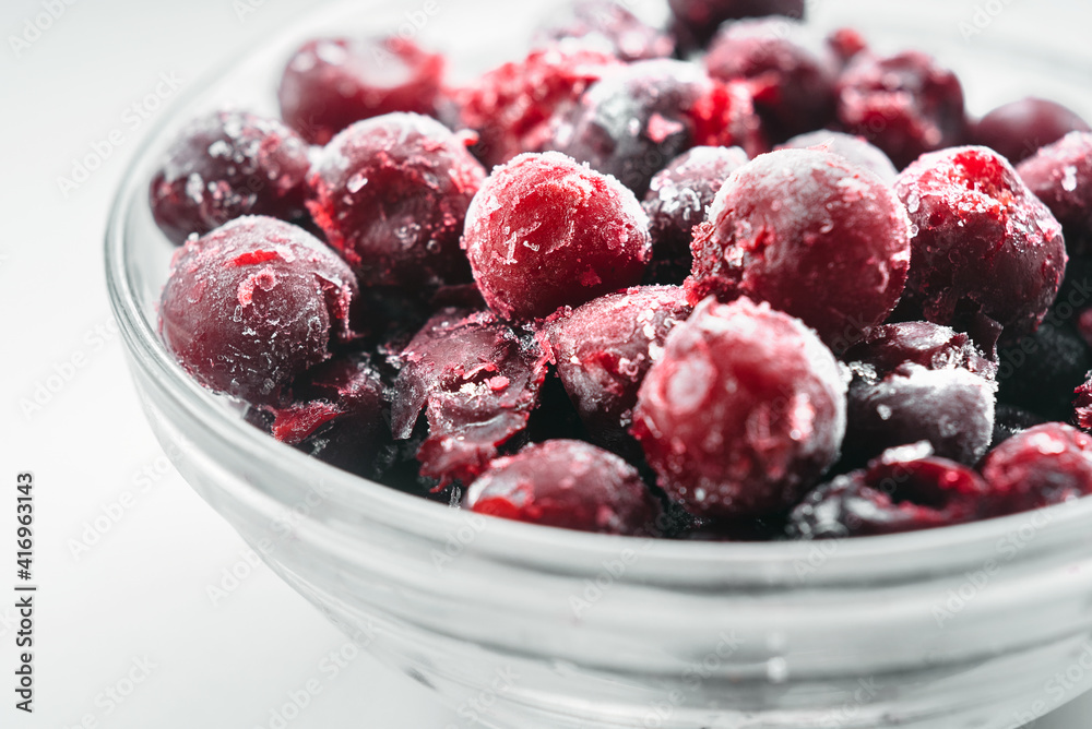 Frozen cherries in a glass bowl on white background Frozen cherries in a glass bowl on white background