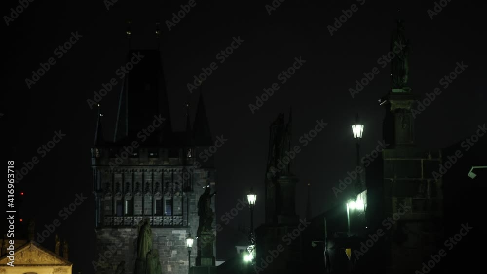 Shot of lantern on street lights on Charles Bridge and in the background the old stone bridge tower at night in the center of Prague Shot of lantern on street lights on Charles Bridge and in the background the old stone bridge tower at night in the center of Prague