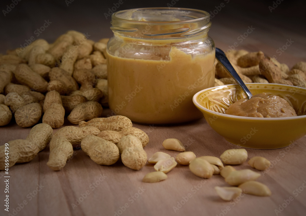 Peanuts and peanut butter in a jar on the table close-up stock images. Pile of peanuts and a glass of peanut butter on a wooden background detail stock photo Peanuts and peanut butter in a jar on the table close-up stock images. Pile of peanuts and a glass of peanut butter on a wooden background detail stock photo