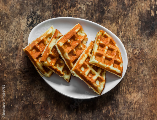 Cottage cheese waffles - delicious sweet dessert on a wooden background, top view