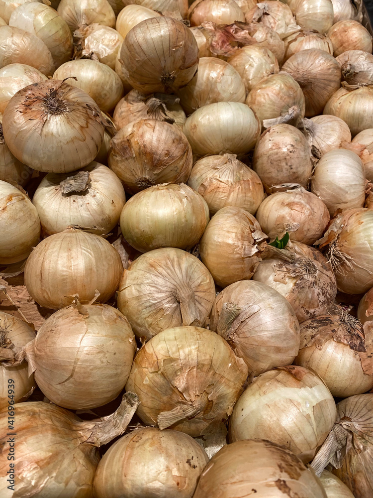 Agricultural background, a pile of beautiful bulb onions. Wallpaper and texture Agricultural background, a pile of beautiful bulb onions. Wallpaper and texture