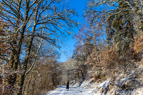 Man walking on a snowy road during a zen sesshin (retreat) in Lanau, Cantal. France. 19.02.2018 photo