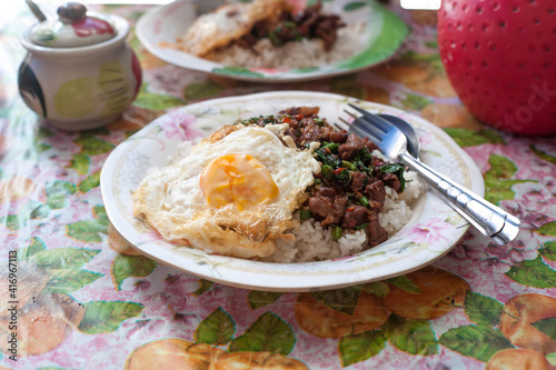 Stir-fried Thai basil with beef and a fried egg at a street food vendor in Bangkok Thailand
