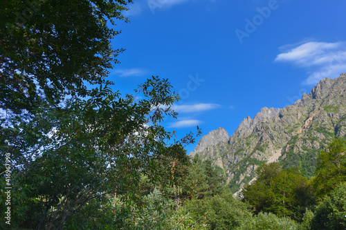 Beautiful mountain peaks of the North Caucasus against the backdrop of a blue cloudy sky. Republic of North Ossetia - Alania