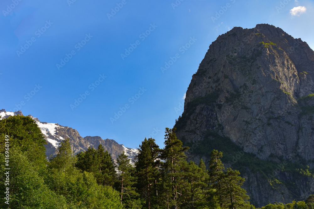 Beautiful mountain peaks of the North Caucasus against the backdrop of a blue cloudy sky. Republic of North Ossetia - Alania