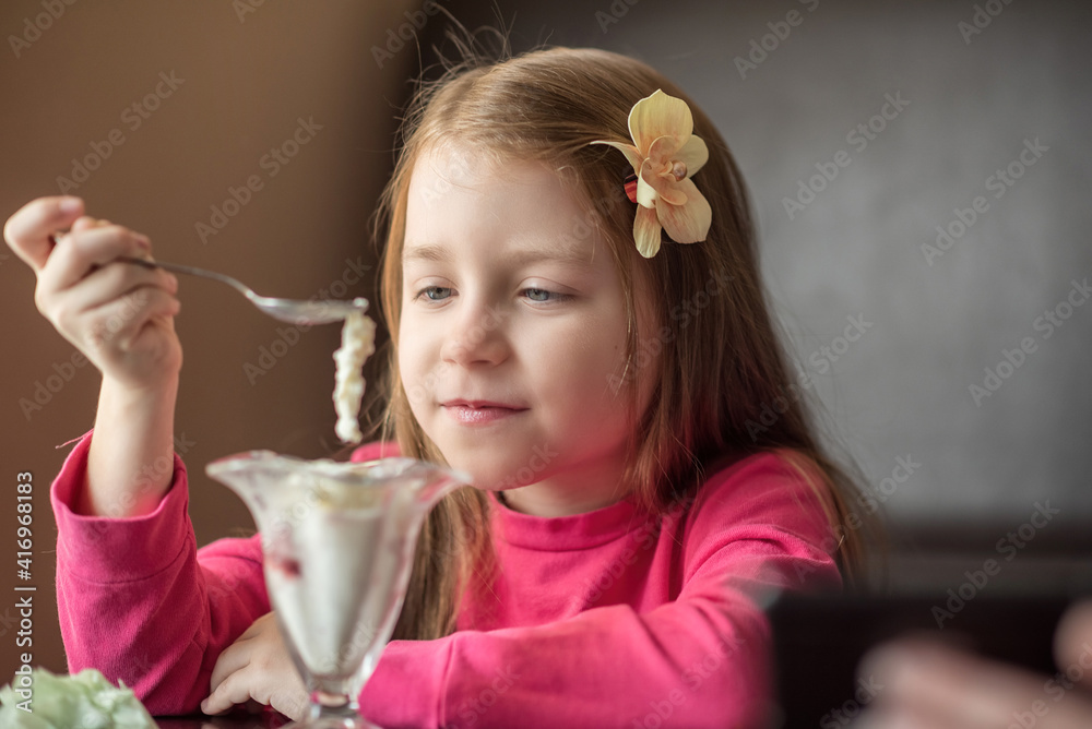 Beautiful girl in a cafe eats ice cream, close-up. Beautiful girl in a cafe eats ice cream, close-up.