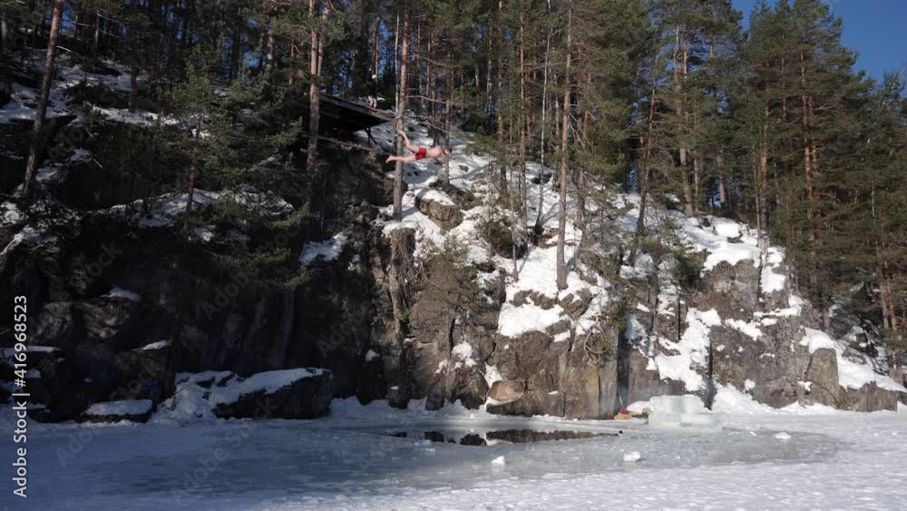 Crazy man in underwear jumps from a cliff to a hole in the ice - slow motion death dive Crazy man in underwear jumps from a cliff to a hole in the ice - slow motion death dive