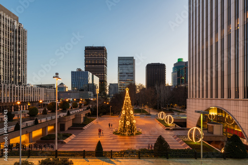 Wide-angle view of the AZCA business and financial district in Madrid with the traditional illuminated Christmas tree rising in its center. photo