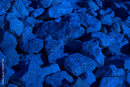 Fényképezés A pile of rocks with shadows from the latter day sun, and tinted overall blue