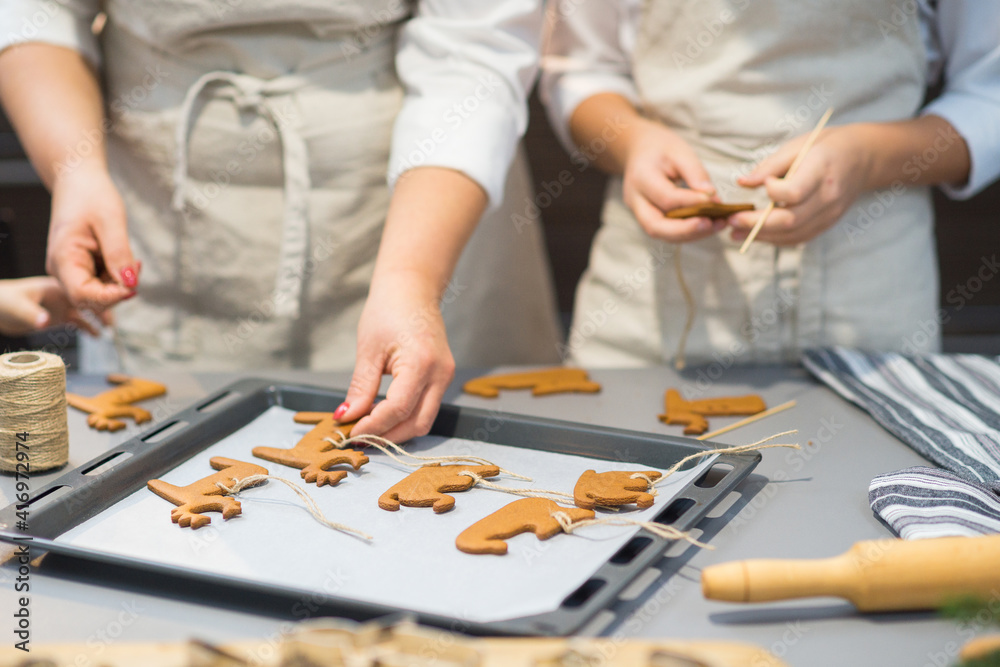 the process of making gingerbread. baking holiday cookies at home. cookies of different shapes on a baking sheet