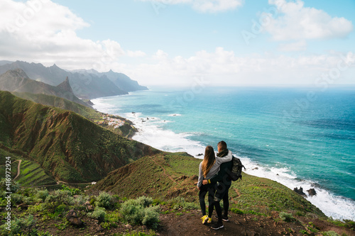 couple looking at a mountain, nature and sea landscape from the top of a mountain. Mountain and hiking. Concept: Adventure, art, travel.