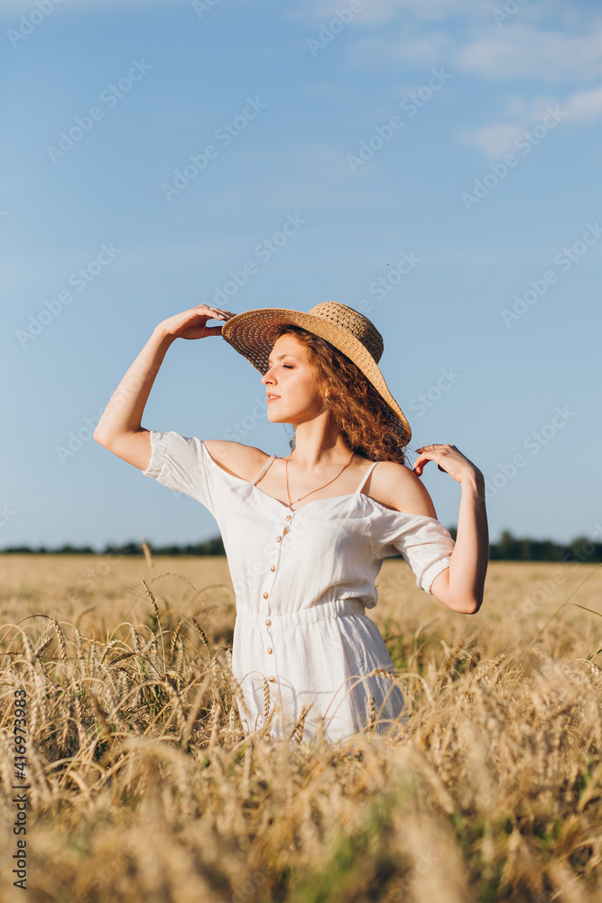 Girl with long curly hair poses in a wheat field Girl with long curly hair poses in a wheat field