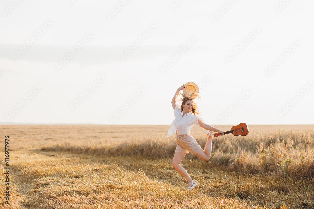 Girl with long curly hair poses in a wheat field Girl with long curly hair poses in a wheat field