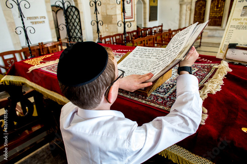 The 4 sephardic synagogues, Jerusalem old city, Israel. Boy reading at the teva. photo