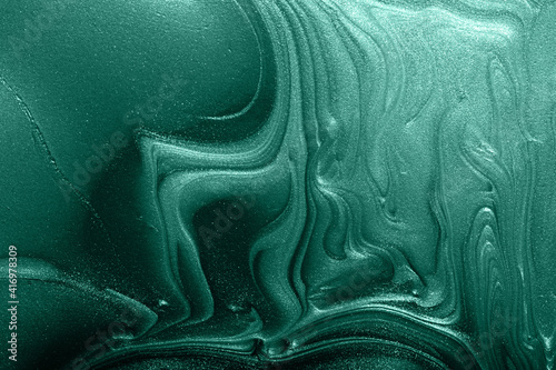 Beautiful monochrome turquoise stains of liquid nail polish,fluid art technique.Shimmer marble background.Liquid stripy paint texture.Nail laquer flow modern backdrop.Minimalistic concept.Copy space.