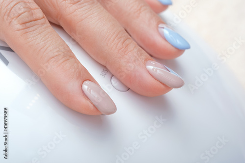 Close-Up Of Woman Fingers With Nail Art. Woman Hand With Beige and Blue Nail Polish