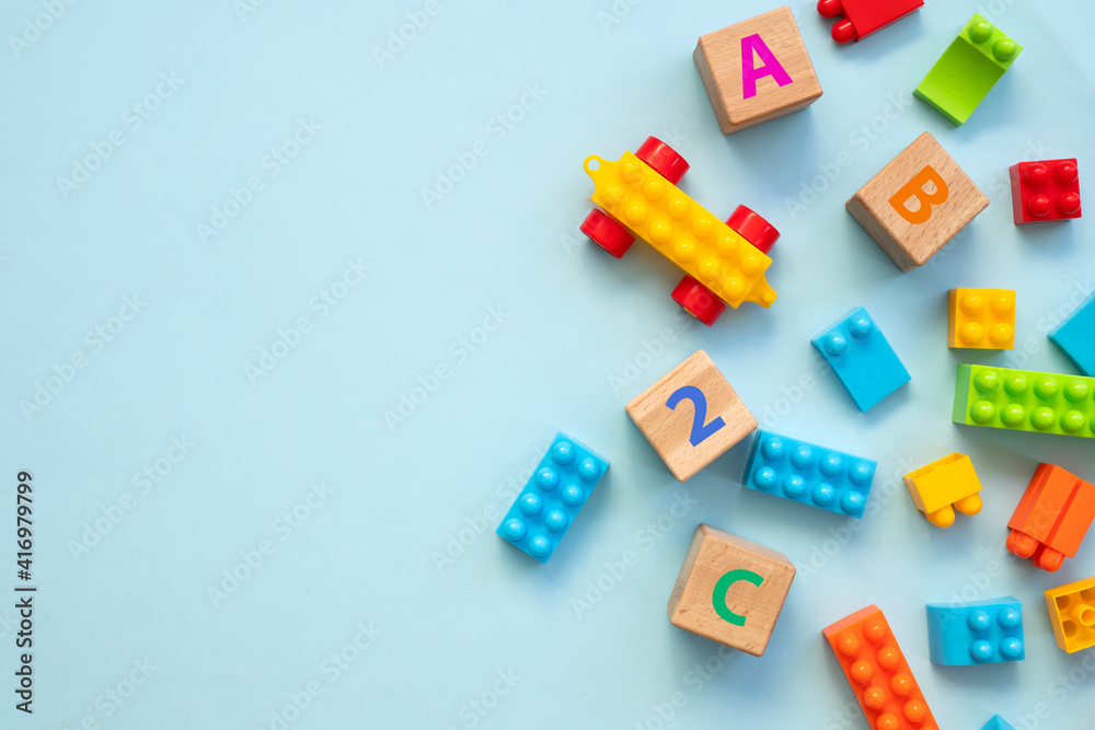 Top view of colorful bricks with toys on blue table background. Figures and alphabet signs. Education concept Top view of colorful bricks with toys on blue table background. Figures and alphabet signs. Education concept