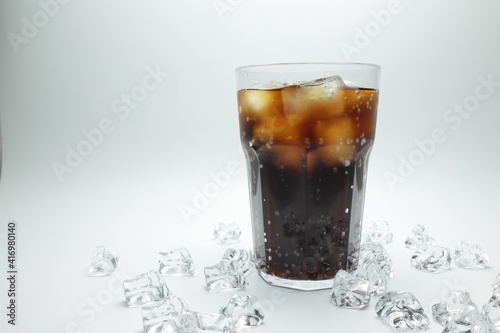 cola in glass with ice on white background