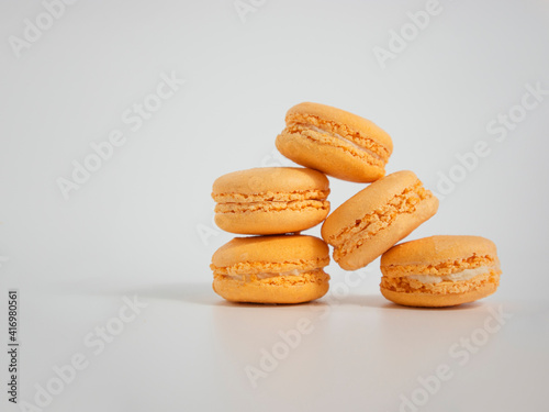 Colorful french macaron dessert, stack of orange macarons cakes, copy space