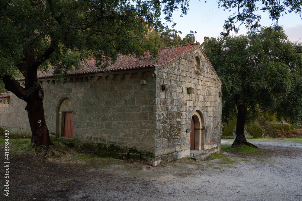 Landscape view of Sao Pedro chapel with trees and boulders in Monsanto, Portugal